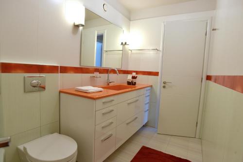 a bathroom with a sink and a toilet and a mirror at The Villa of the Winds in Néa Kíos