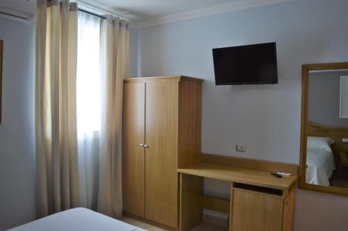 a bedroom with a bed and a television and a mirror at Villa Dei Fiori in Montoro Inferiore