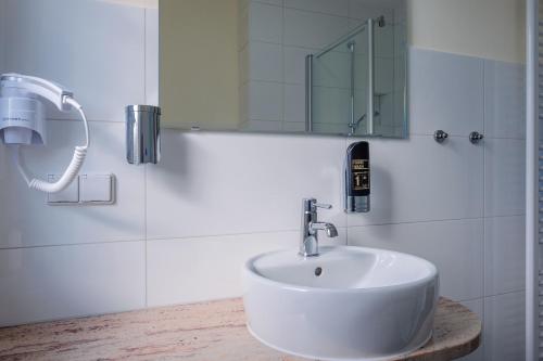 史托科的住宿－Restaurant & Pension Storchenklause，浴室设有白色水槽和镜子
