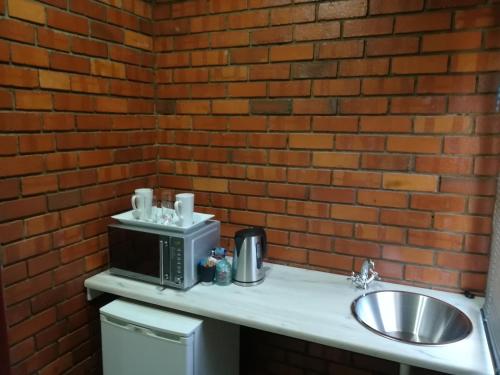 a kitchen counter with a microwave and a sink at Tranquil House B&B @ 121 Berry St in Queenstown