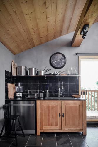 a kitchen with a sink and a clock on the wall at Chalet Nantailly in Hauteluce
