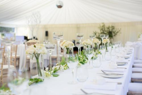 a table with glasses and white flowers on it at The Greenway Hotel & Spa in Cheltenham