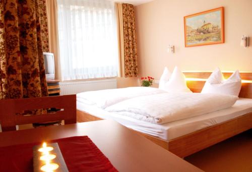 Habitación de hotel con 2 camas y mesa en Schell Schokoladen, en Gundelsheim