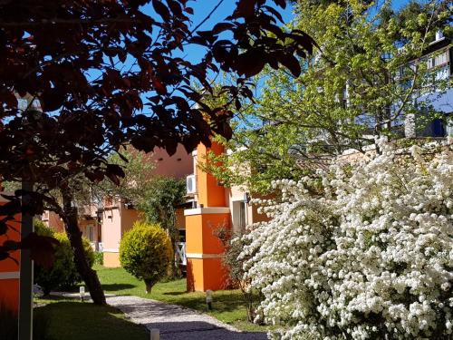 a bush of white flowers in front of a building at Complejo Viva Zapata in Mar de las Pampas