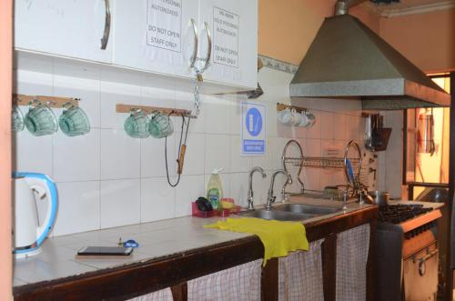a kitchen with a sink and a stove at Hostal Namaste in Salta