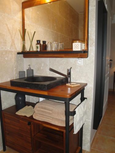 a bathroom vanity with a sink and a mirror at La Longere De Cabanes in Cabanès