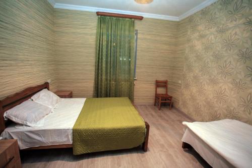 a bedroom with two beds and a window and a chair at Guest House In Tbilisi in Tbilisi City