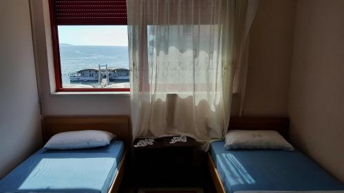 twee bedden in een kamer met een raam bij 2 Room City-Sea apartment in Durrës