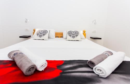 1 dormitorio con cama blanca, toallas y almohadas en Luxury suites Juričević, en Duće