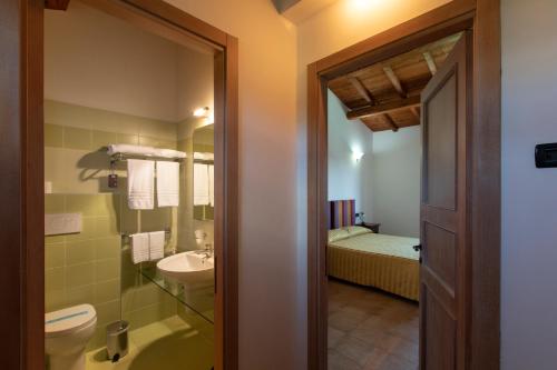 a bathroom with a sink and a toilet and a bed at Masseria Grande in Montecilfone