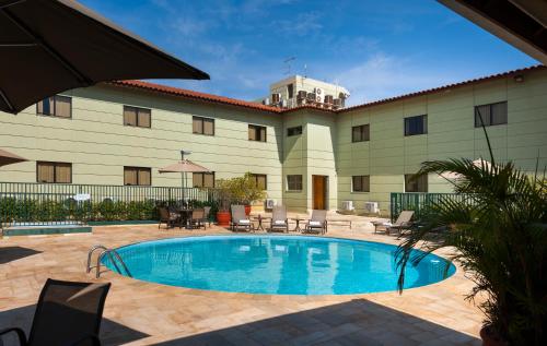 a swimming pool in front of a building at Matiz Jaguariúna in Jaguariúna