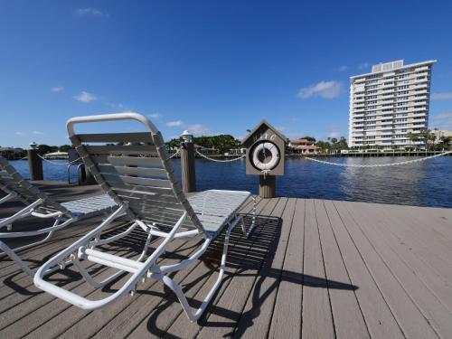 two lawn chairs sitting on a dock next to the water at Holiday Isle Yacht Club in Fort Lauderdale