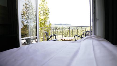 a bedroom with a bed and a large window at Taste Style Hotel Bären Auggen in Auggen