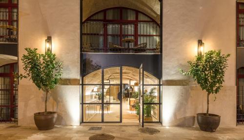 a lobby with a glass door with two potted trees at Fil Suites in Palma de Mallorca