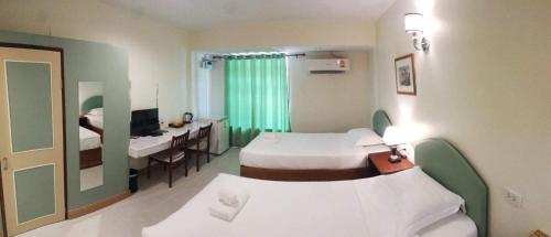 a hotel room with two beds and a desk and a mirror at Mamaungpaa Hill resort in Ta Khli