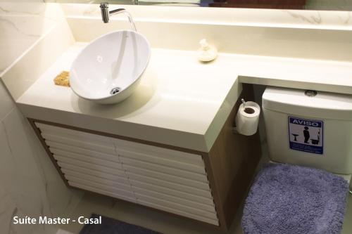 a bathroom with a white sink and a toilet at casa duplex sergio e claudia in Vitória