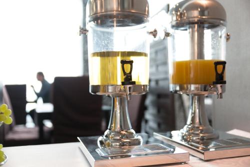 two glasses of orange juice sitting on a table at Hotel Modena in Bratislava