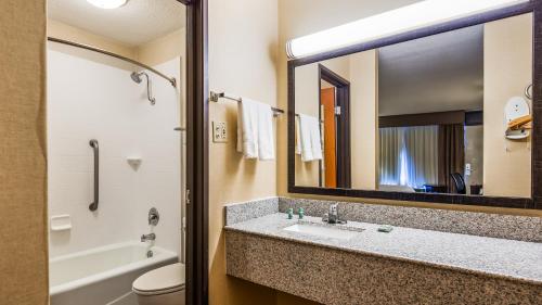 a bathroom with a sink and a tub and a mirror at Best Western Northgate Inn Pampa in Pampa