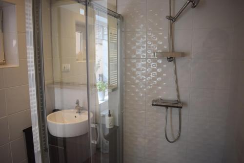 een badkamer met een douche en een wastafel bij Buborék apartman in Tata