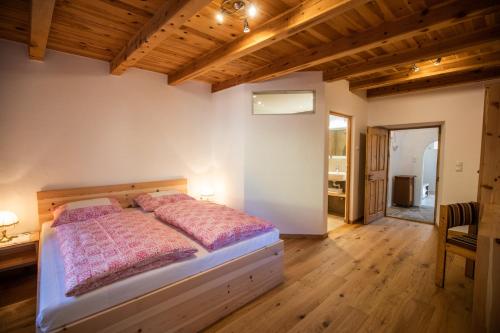 1 dormitorio con 1 cama en una habitación con techos de madera en Brunnerhof-Schrof en Collalbo