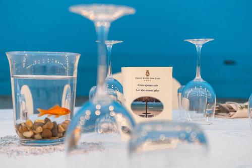 a table with wine glasses and a goldfish in a vase at Grand Hotel Don Juan in Giulianova