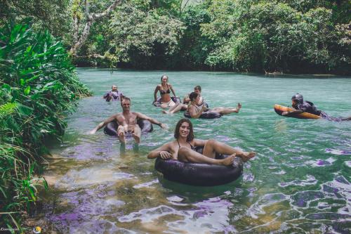 a group of people are sitting in the water on tubes at Viñas Hotel in Lanquín