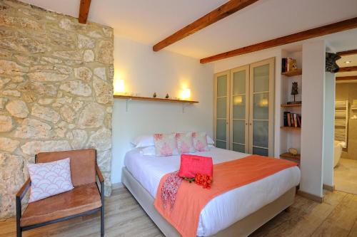 1 dormitorio con cama y pared de piedra en Lodge de Charme A Cheda, en Bonifacio