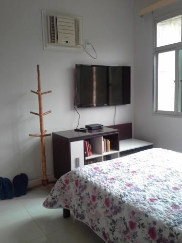 a bedroom with a bed and a flat screen tv at casa duplex sergio e claudia in Vitória