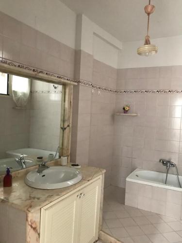 Un baño con lavabo, bañera y espejo. en Casa della Luna, en Amalfi