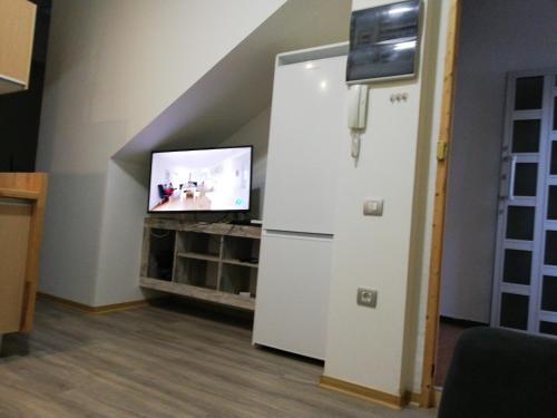 Habitación con nevera blanca y TV. en Apartamento la piedra viva 3 arinaga, en Arinaga