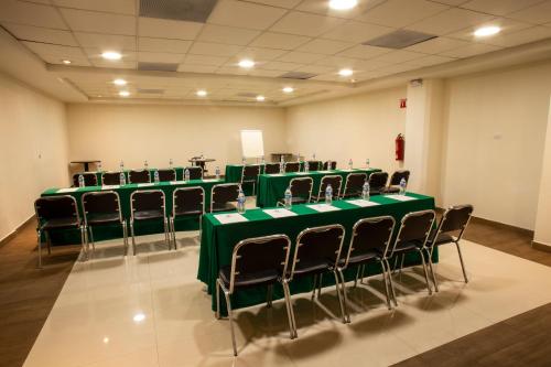 a row of tables and chairs in a room at Hotel Plaza Calzada in Monterrey