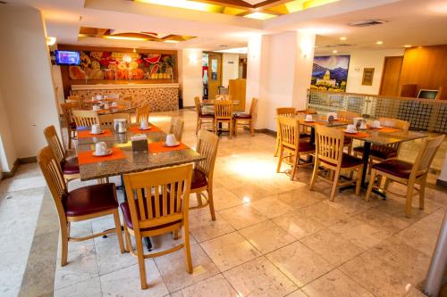 a dining room with tables and chairs in a restaurant at Hotel Plaza Calzada in Monterrey