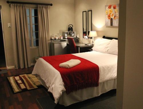 pokój hotelowy z łóżkiem z czerwonym kocem w obiekcie Tranquil House B&B 10 Berry St w mieście Queenstown