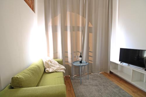a living room with a green couch and a television at Aparthotel Tectum TectumApartments in Wrocław