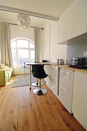 a kitchen with a table and a chair in a room at Aparthotel Tectum TectumApartments in Wrocław