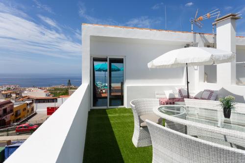 balkon z białymi krzesłami i widokiem na ocean w obiekcie "ATIS" w mieście Puerto de Santiago