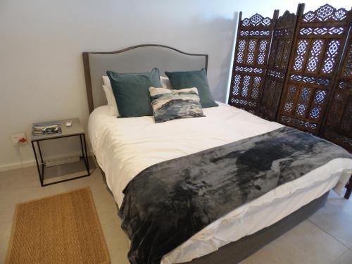 a bedroom with a large bed with pillows and a table at Ocean Dune Studio in Sibaya