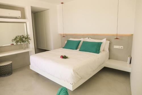 a bedroom with a bed with green and white pillows at Thalasses Villas Skiathos in Skiathos Town