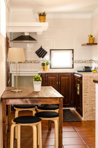 a kitchen with a wooden table and stools at Casa da Avó Tina in Castelo de Vide