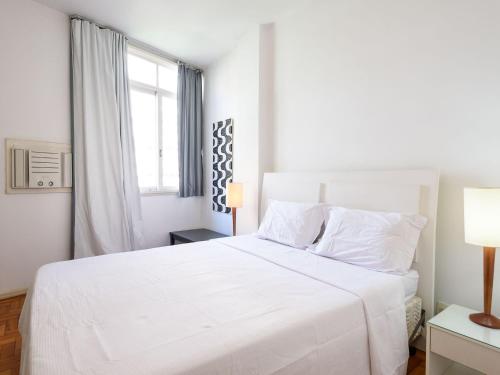 a white bedroom with a white bed and a window at Amplo 3Qtos a 200m da Praia de Ipanema | BC 33/502 in Rio de Janeiro
