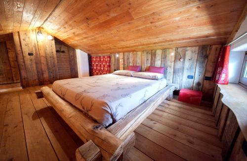 una camera con un letto in una cabina di legno di maison povil a Quart