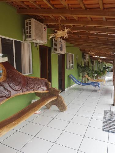 a wooden bench in a room with green walls at Pousada Cantinho de Casa in Nobres