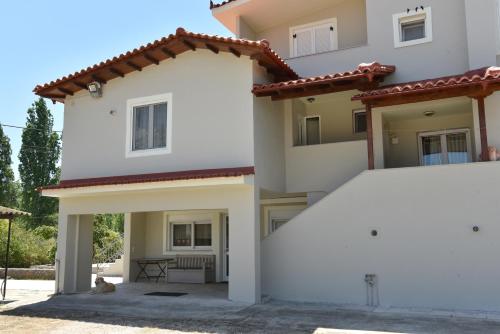 a white house with a dog sitting in front of it at The Villa of the Winds in Néa Kíos