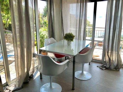 a glass table and chairs in front of a window at LOFT-Beach-apartments RATKO in Novi Vinodolski