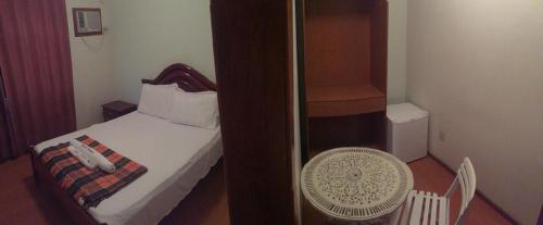 a small room with a small bed and a bathroom at Hotel & Restaurante Paraíso - By Up Hotel in Ponte Nova