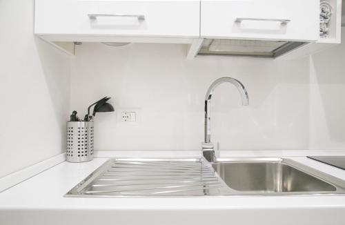 una cucina bianca con lavandino e bancone di Amazing, new & fully furnished studio in Duomo a Milano