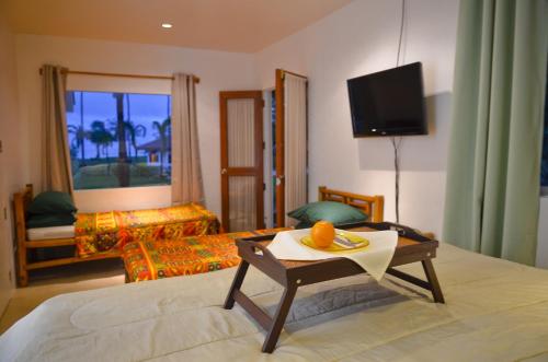 a hotel room with a bed and a table with an orange on it at Punta Bulata White Beach Resort & Spa in Sipalay
