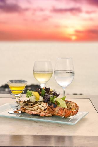 a plate of food with two glasses of wine at Ambergris Cay - Private Island All-Inclusive in Big Ambergris Cay