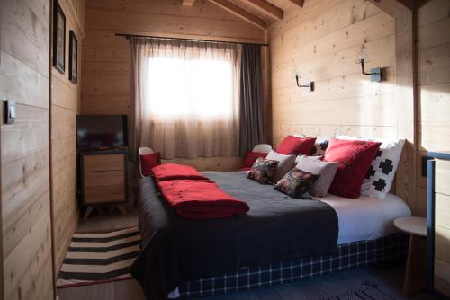 a bedroom with a large bed with red pillows at Chalet 4M Les Carroz et son Spa in Les Carroz d'Araches