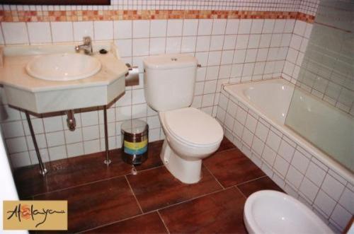 een badkamer met een toilet, een wastafel en een bad bij Hostal Atalaya in Minas de Ríotinto